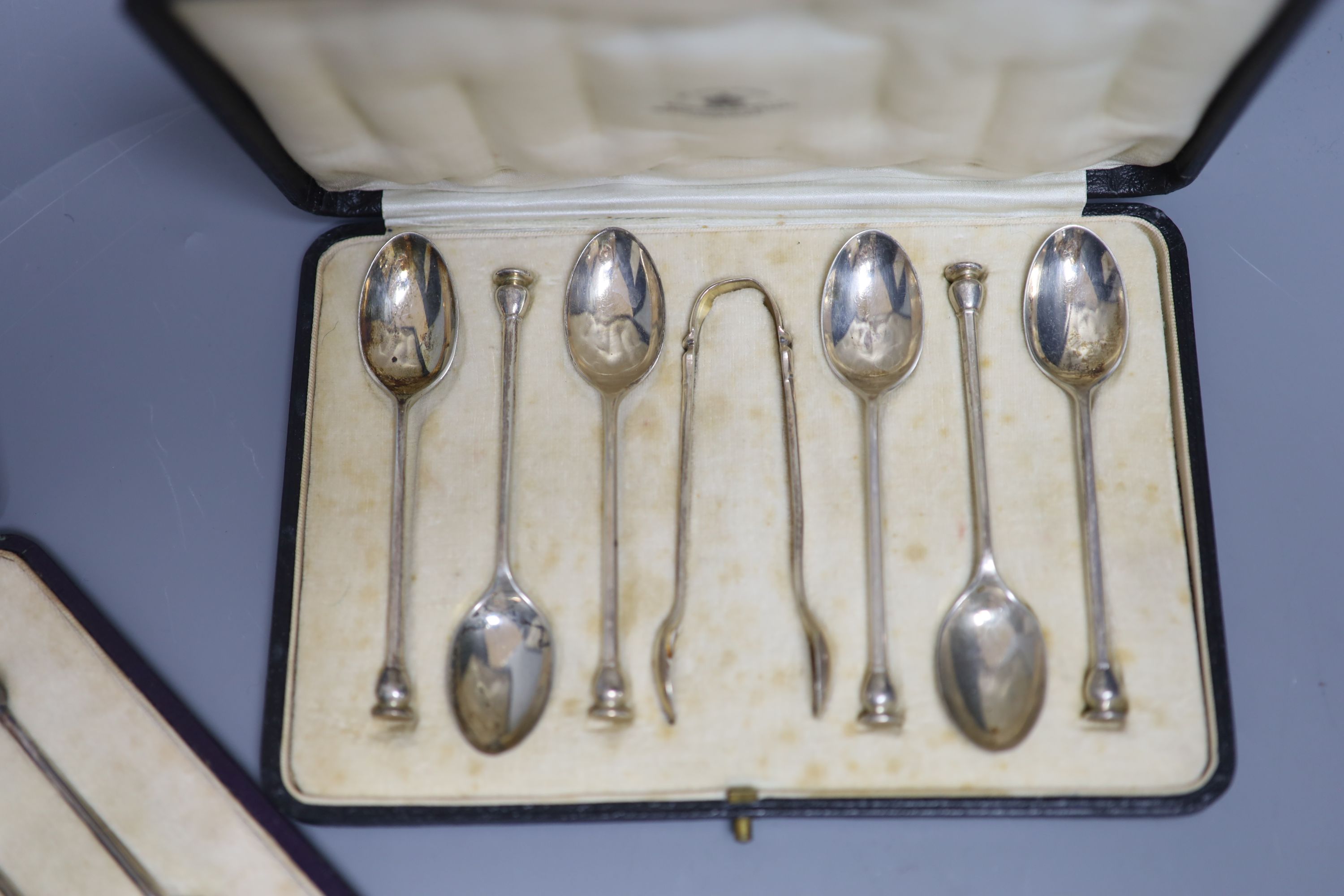 A cased set of six seal top teaspoons and tongs and a cased set of silver silver bean end coffee spoons.